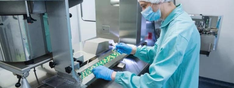 Pharmaceutical technician working on the production of pills.
