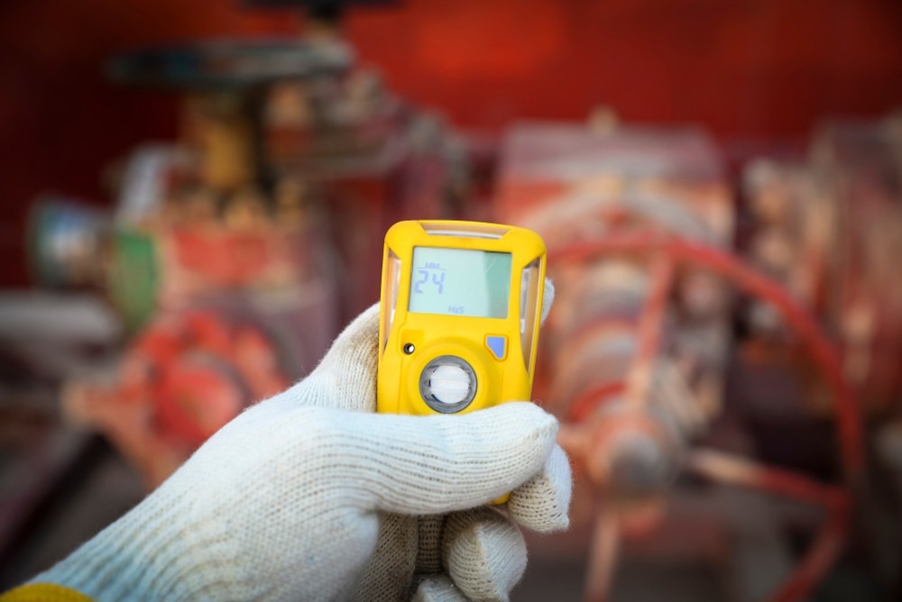 Refinery technician checking gas with his pocket type H2S Gas detector